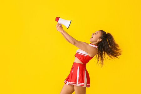 Emotional cheerleader with megaphone on color backgroundの写真素材