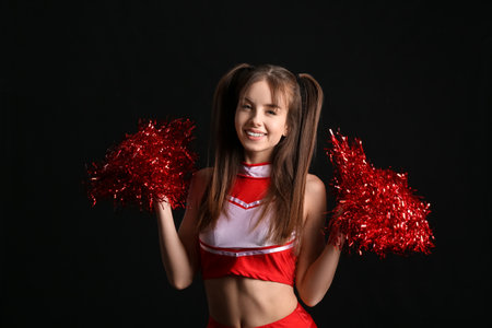 Beautiful young cheerleader on dark backgroundの写真素材