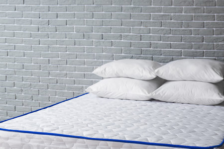 Soft orthopedic mattress on bed in roomの写真素材