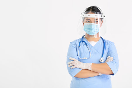 Portrait of female Asian doctor in medical mask on light backgroundの写真素材