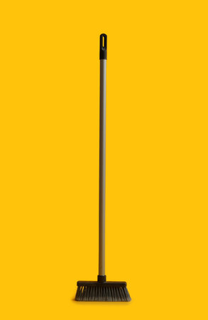Plastic cleaning broom on yellow backgroundの写真素材