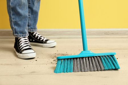 Woman sweeping floor with broomの写真素材