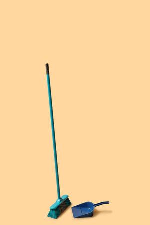 Cleaning broom and dustpan on orange backgroundの写真素材