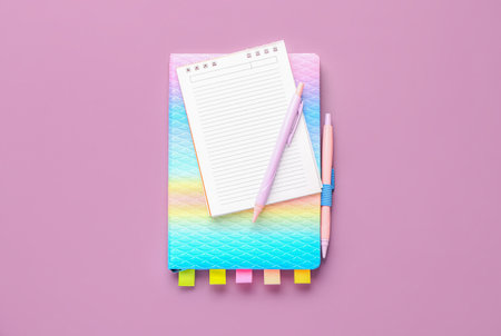 Notebooks and pens on lilac backgroundの写真素材