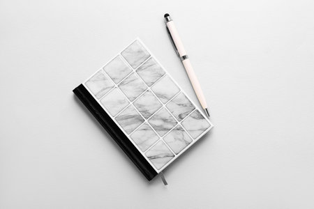 Stylish notebook and pen on light backgroundの写真素材