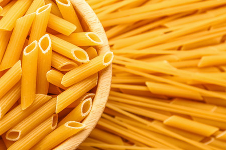 Bowl of raw penne pasta, closeup