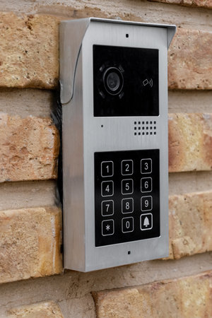 Modern intercom on brick wall outdoors, closeup