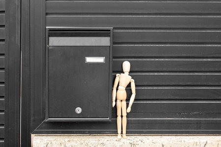 Fence with mailbox and wooden mannequin outdoors, closeupの写真素材