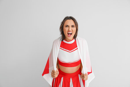 Aggressive cheerleader with the flag of England on light background