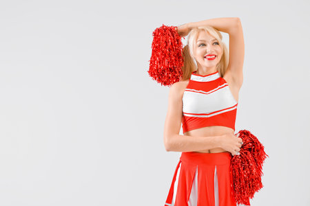 Beautiful cheerleader on light background