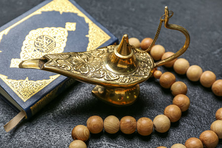 Aladdin lamp of wishes, Koran and prayer beads for Ramadan on dark background, closeupの写真素材