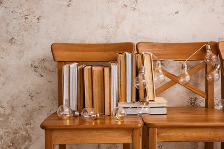 Stack of books with garland on chairsの写真素材