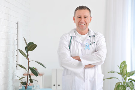 Oncologist with blue ribbon in clinic. Prostate cancer awareness concept