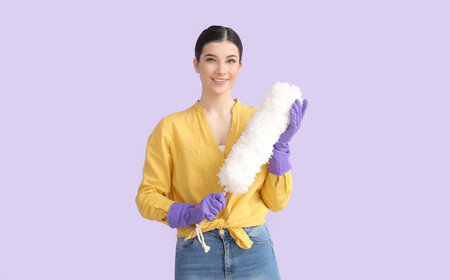 Young woman with dust brush on color background