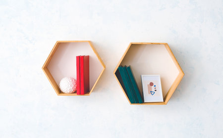 Shelves with books and picture hanging on light wallの写真素材