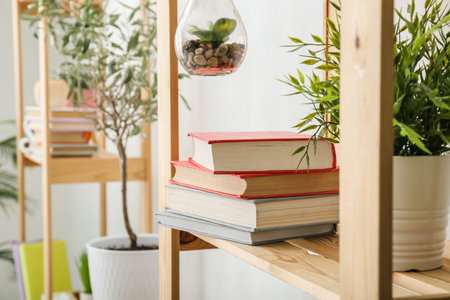 Shelf units with books and houseplants near light wall, closeupの写真素材