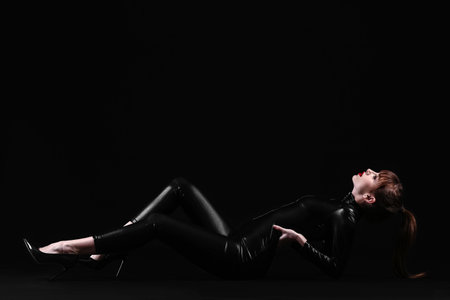 Beautiful fashionable young woman on dark backgroundの写真素材