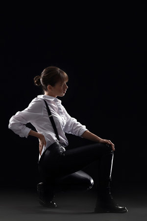 Beautiful fashionable young woman on dark backgroundの写真素材