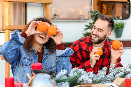 Happy young couple celebrating Christmas outdoorsの写真素材