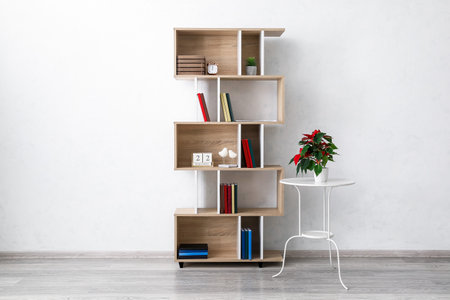 Modern shelf unit and table with houseplant near light wallの写真素材