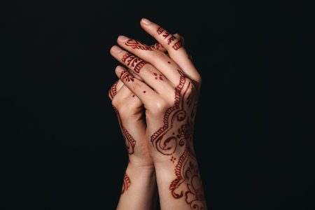 Beautiful female hands with henna tattoo on dark backgroundの写真素材