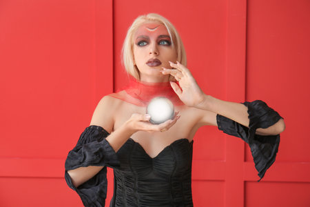 Fortune teller with magic ball on color background