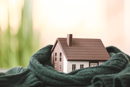 Figure of house and warm scarf outdoors. Concept of heating seasonの写真素材