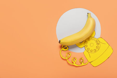 Creative composition with banana and telephone made of paper on color backgroundの写真素材
