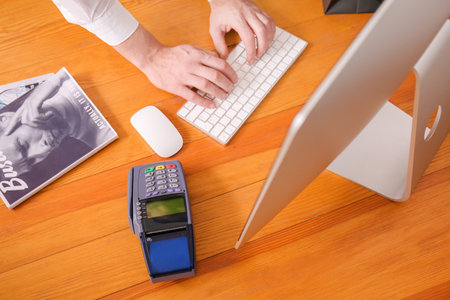 Payment terminal on table of seller using computer in shopの写真素材