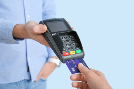 Buyer paying for purchase via terminal on color backgroundの写真素材