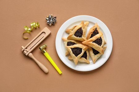 Hamantaschen cookies and noisemakers for Purim holiday on brown backgroundの写真素材