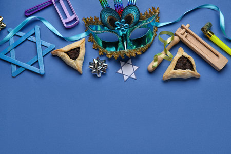 Hamantaschen cookies, carnival mask and rattles for Purim holiday on blue backgroundの写真素材