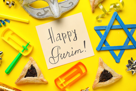 Card with text HAPPY PURIM, Hamantaschen cookies, carnival mask and rattles on yellow backgroundの写真素材