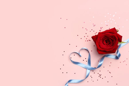 Rose flower and heart made of blue satin ribbon on pink background. Valentine's Day celebrationの写真素材