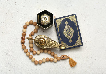 Aladdin lamp of wishes, Muslim lantern, Koran and prayer beads for Ramadan on light background