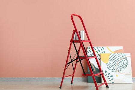 Maintenance ladder with cans of paint and paintings near color wallの写真素材