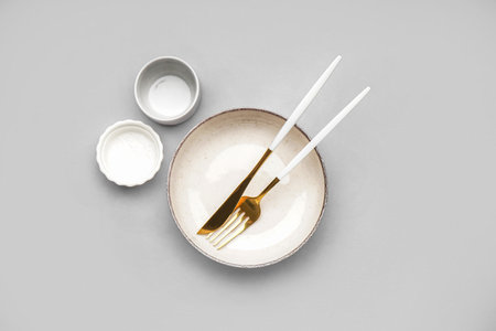 Table setting with golden cutlery on gray backgroundの写真素材