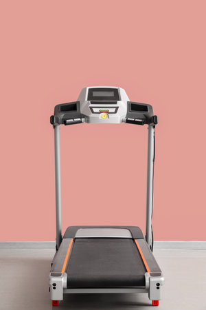 Interior of room with modern treadmill near pink wall