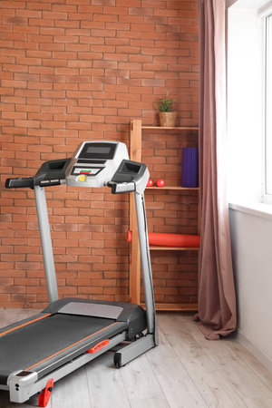 Interior of room with modern treadmill near window