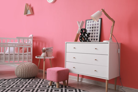 Interior of modern children's room with comfortable bed and chest of drawers