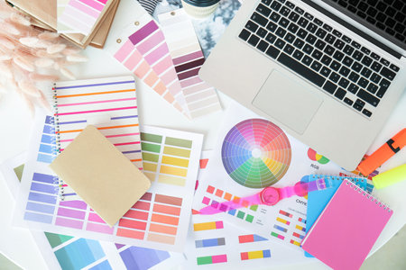 Modern laptop and color palettes on table of graphic designer in office