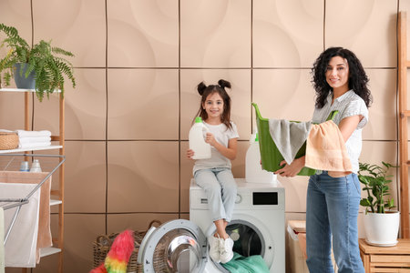 Mother and daughter doing laundry at homeの写真素材
