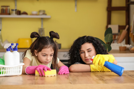 Mother and daughter cleaning table in the kitchenの写真素材