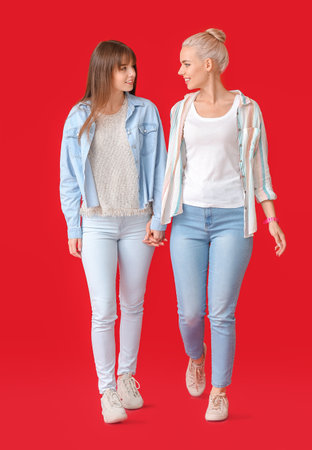 Young lesbian couple on color backgroundの写真素材