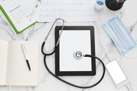 Tablet computer with stethoscope, cardiogram and accessories of doctor on white backgroundの写真素材