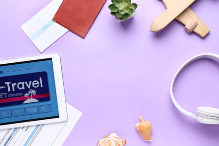 Frame made of tablet computer with gift voucher and travel accessories on color backgroundの写真素材