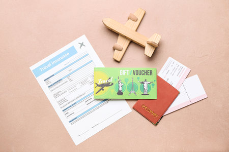 Set of travel documents, wooden airplane and gift voucher on color backgroundの写真素材