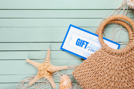 Travel gift voucher, seashells and bag on color backgroundの写真素材
