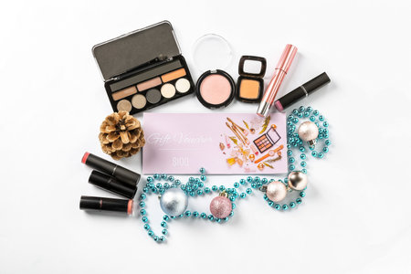Gift certificate, decorative cosmetics and female accessories on white backgroundの写真素材