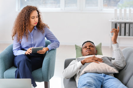 Psychologist working with African-American man in officeの写真素材